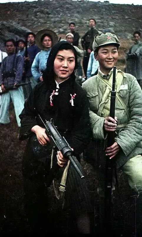 解放军士兵和女民兵。解放军士兵手持的是日本三八式步枪，而女游击队员则拿着美国M3盖德冲锋枪。从他们的脸上可以看出那个年代的朝气和精神，这是与旧时代麻木呆滞的中国人完全不同的表情和目光。