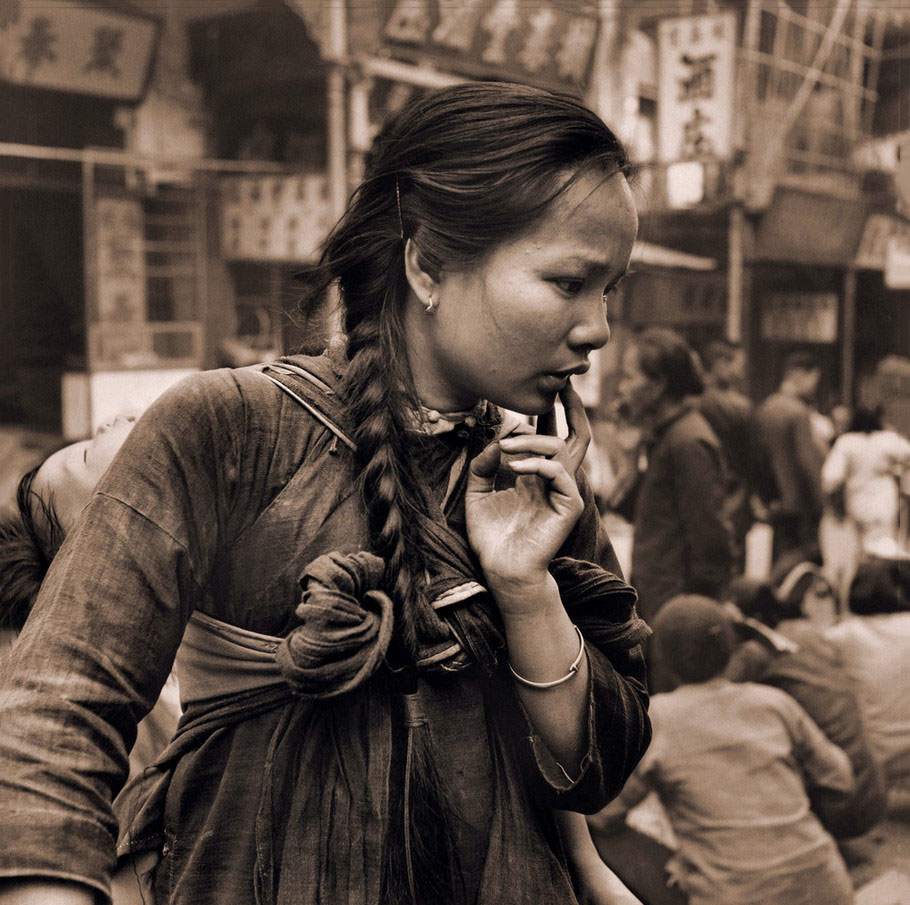 1946年香港，年轻的母亲背着她的一个孩子在市场上回来